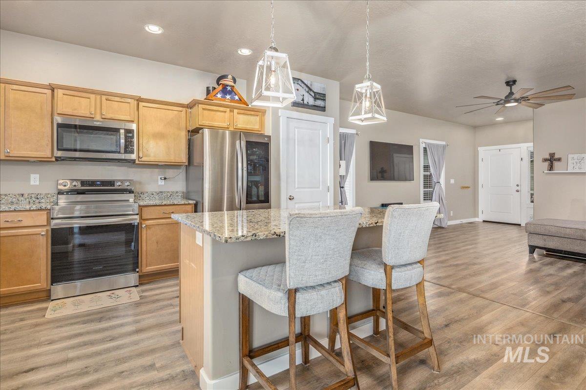 5668 West Old Ranch Street Boise, ID 83714 - Photo 17 of 44 Kitchen featuring stainless steel appliances, a center island, pendant lighting, light wood-type flooring, and recessed lighting
