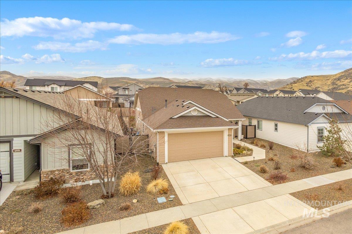 5668 West Old Ranch Street Boise, ID 83714 - Photo 2 of 44 View of front facade featuring driveway, a mountain view, a residential view, a garage, and stone siding