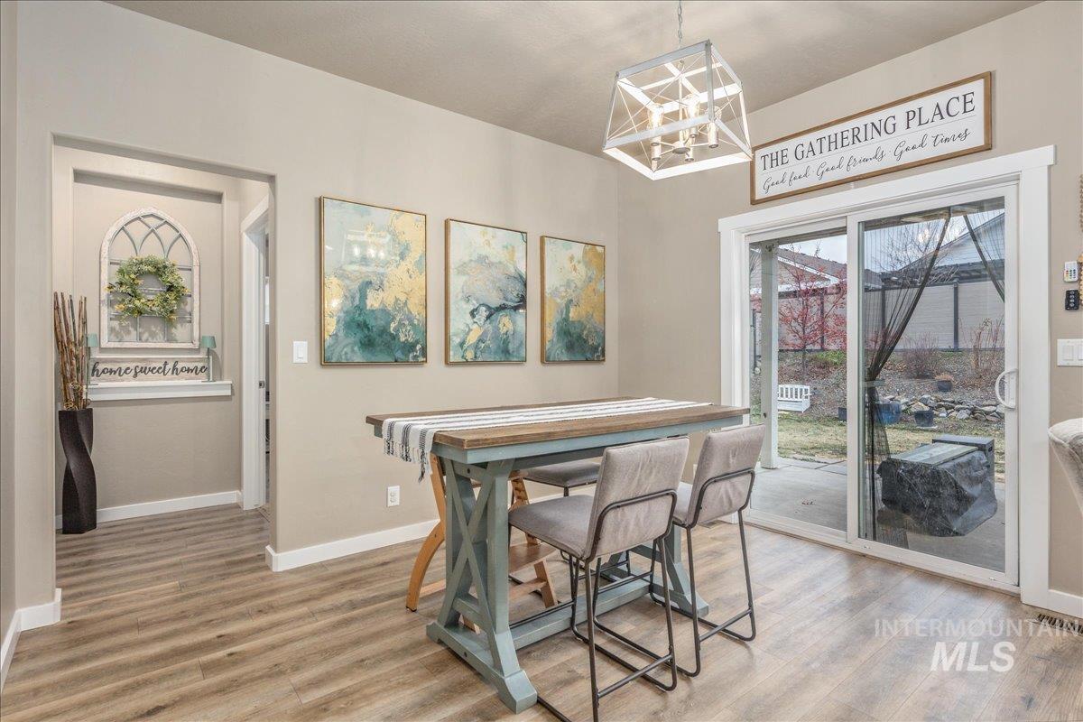 5668 West Old Ranch Street Boise, ID 83714 - Photo 20 of 44 Dining room featuring light wood-style flooring and a chandelier