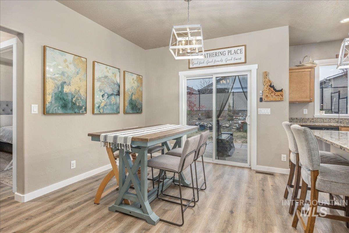 5668 West Old Ranch Street Boise, ID 83714 - Photo 21 of 44 Dining area featuring light wood-style floors and a chandelier