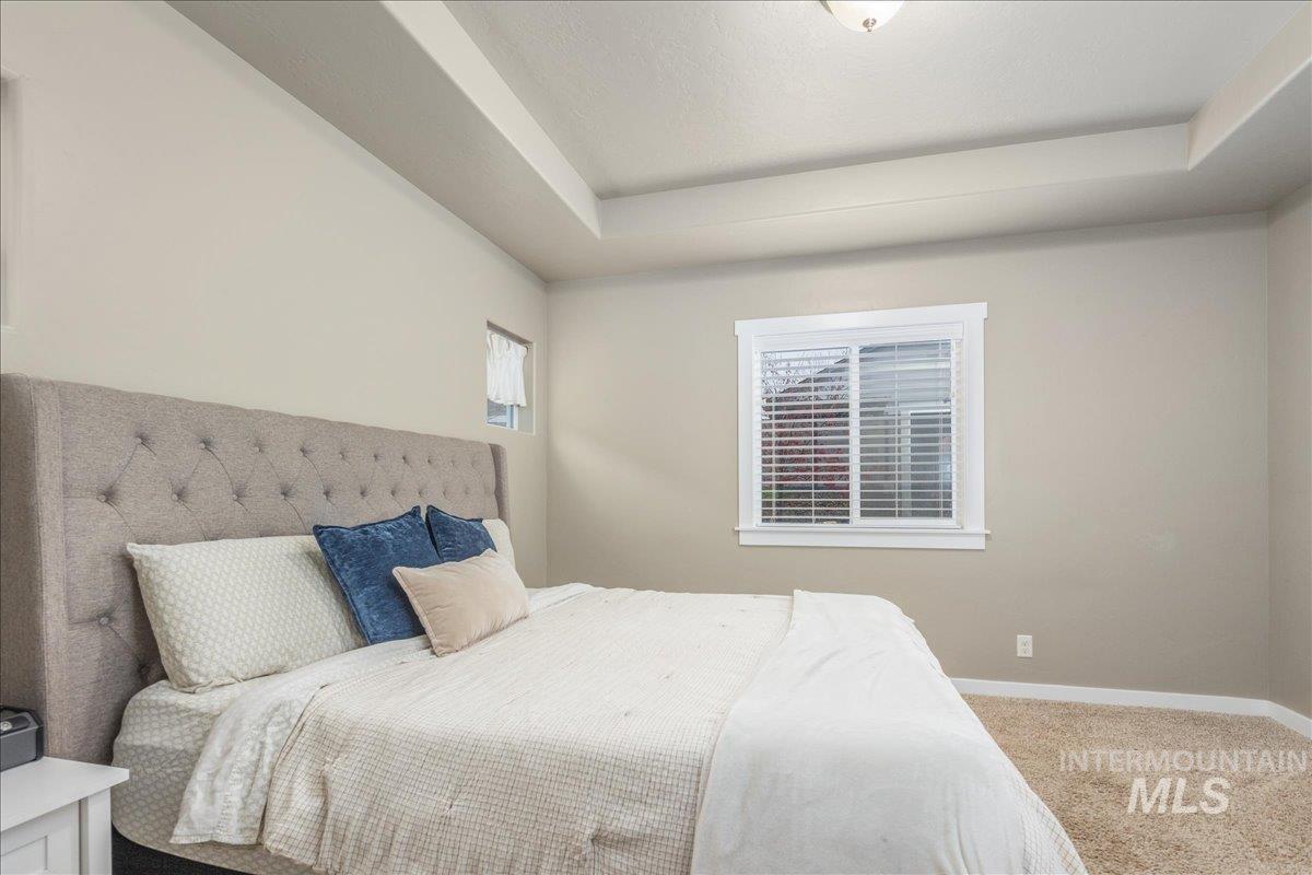 5668 West Old Ranch Street Boise, ID 83714 - Photo 25 of 44 Carpeted bedroom featuring a raised ceiling and baseboards