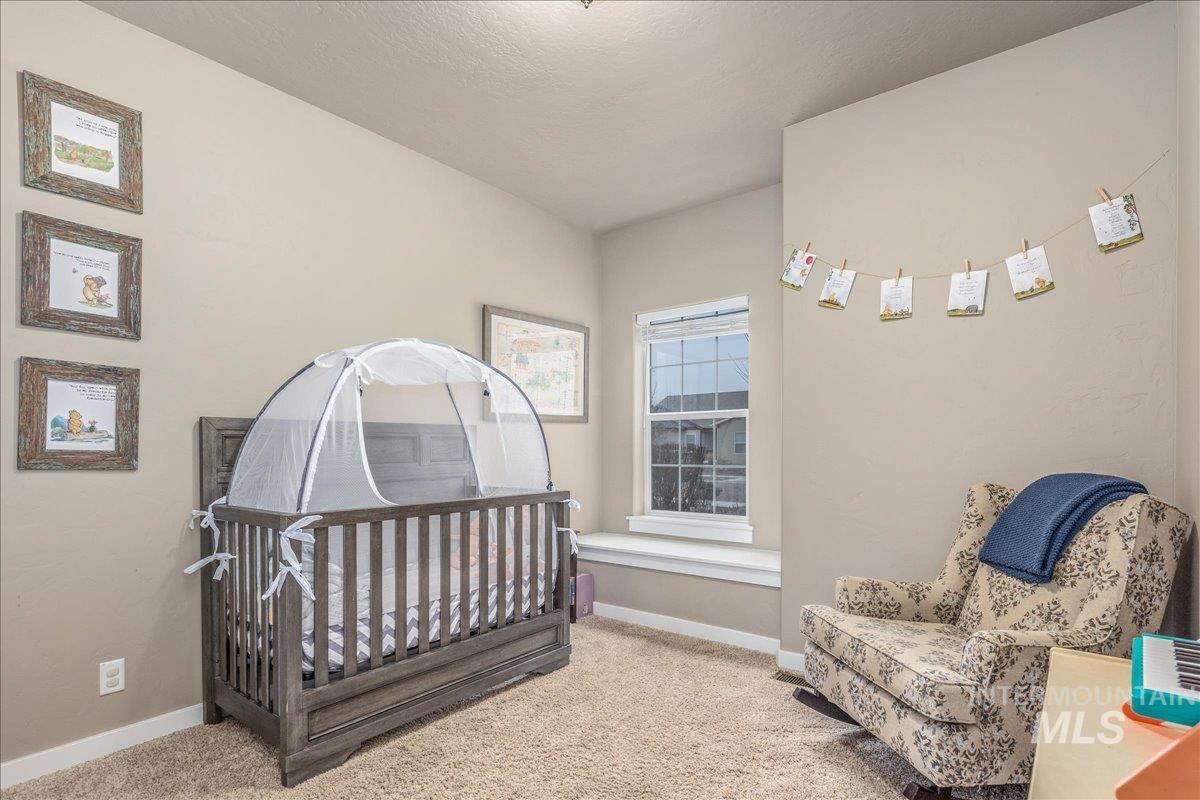 5668 West Old Ranch Street Boise, ID 83714 - Photo 30 of 44 Bedroom featuring carpet flooring, a crib, and a textured ceiling