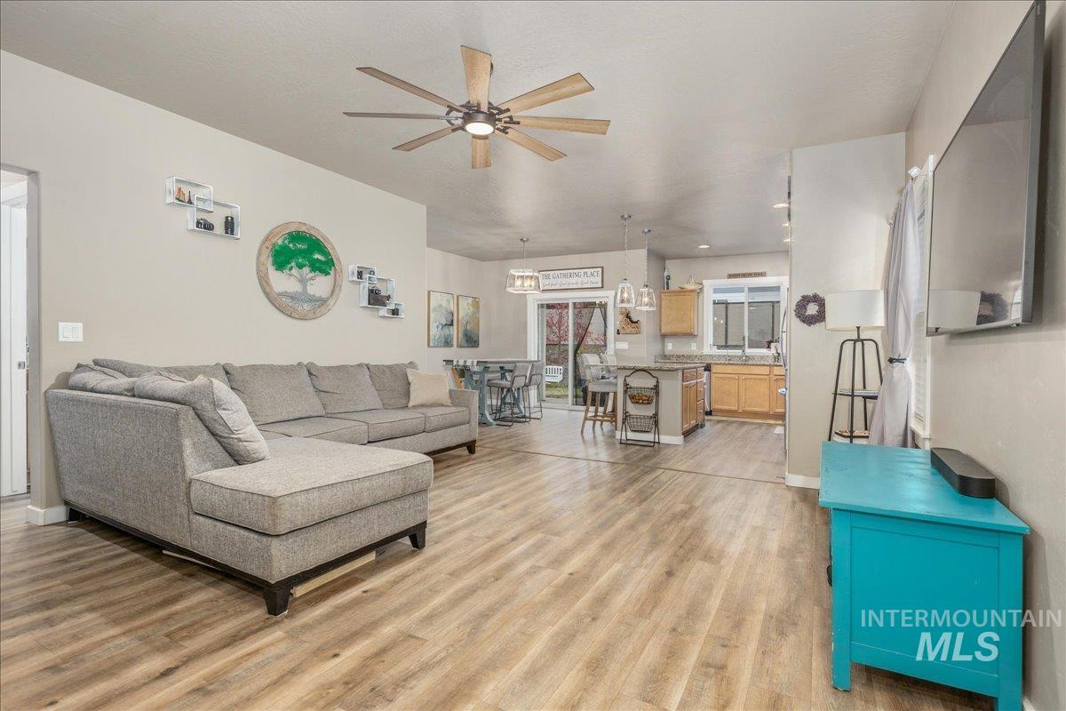 5668 West Old Ranch Street Boise, ID 83714 - Photo 8 of 44 Living area featuring light wood finished floors, ceiling fan, and a chandelier