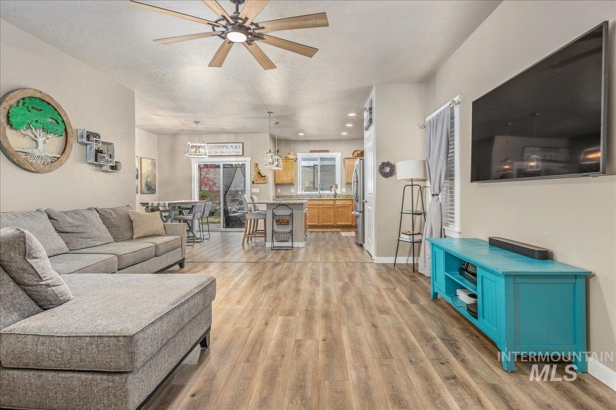 5668 West Old Ranch Street Boise, ID 83714 - Photo 9 of 44 Living room featuring light wood-style floors, a ceiling fan, a textured ceiling, and recessed lighting