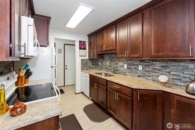 a kitchen with stainless steel appliances granite countertop wooden cabinets a sink and dishwasher