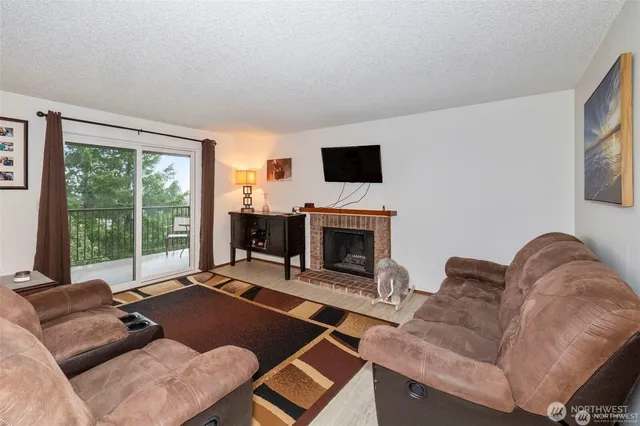 a living room with furniture large window and a fireplace