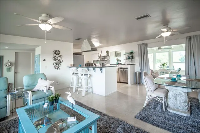 a living room with kitchen island furniture and a chandelier