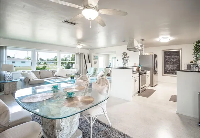 a very nice looking dining room with kitchen island furniture a chandelier and a view of kitchen