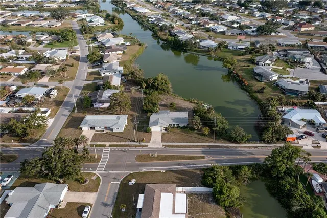 an aerial view of residential houses with outdoor space and lake view