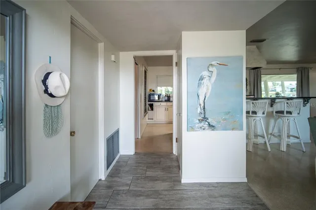 a view of a hallway with wooden floor and a living room