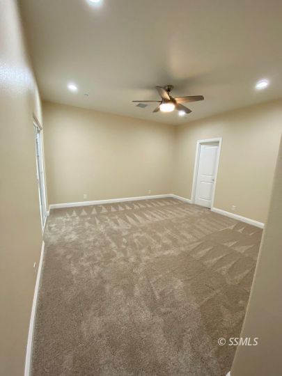 1046 Ocean Avenue Ridgecrest, CA 93555 - Photo 17 of 19 an empty room with a ceiling fan and a window