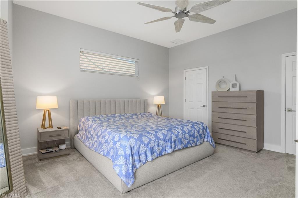 24361 Copperleaf Boulevard Estero, FL 34135 - Photo 16 of 49 a bedroom with a bed and a chandelier