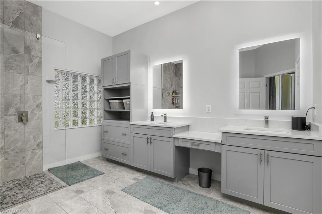 24361 Copperleaf Boulevard Estero, FL 34135 - Photo 18 of 49 a spacious bathroom with a double vanity sink a mirror and a bathtub