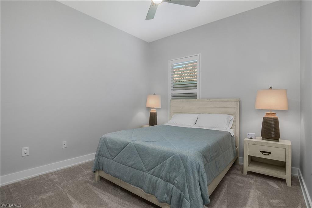 24361 Copperleaf Boulevard Estero, FL 34135 - Photo 22 of 49 a bedroom with a bed and a lamp on the dresser