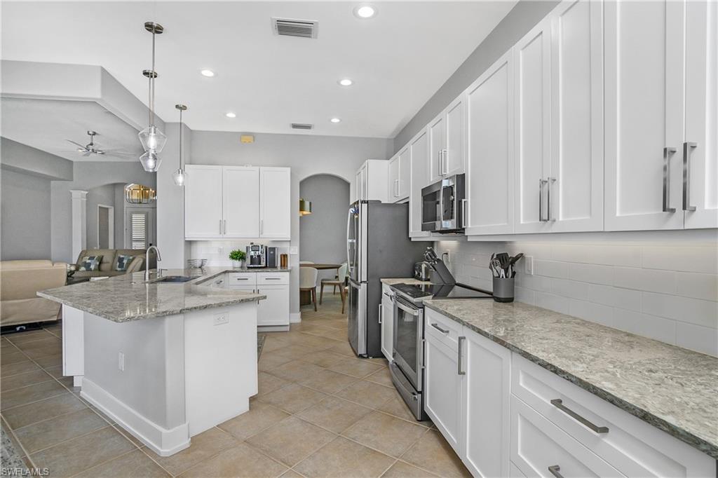 24361 Copperleaf Boulevard Estero, FL 34135 - Photo 8 of 49 a kitchen with stainless steel appliances granite countertop a sink stove and cabinets