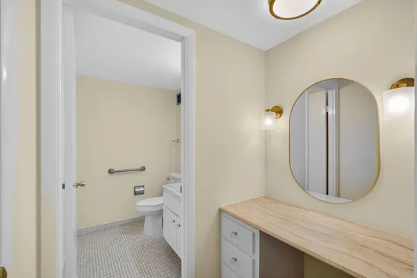 a bathroom with a granite countertop sink a toilet and a mirror