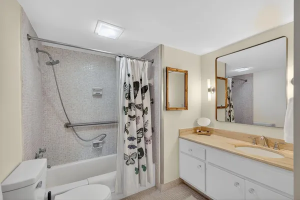 a bathroom with a granite countertop sink toilet and shower