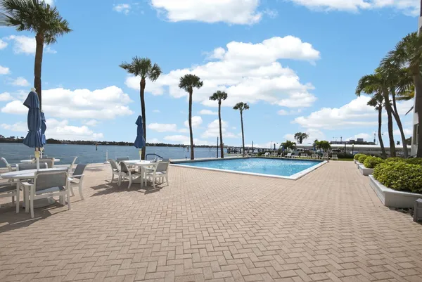 a view of roof deck with a table and chairs & palm trees