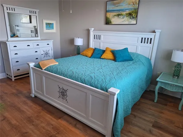 a bedroom with a bed and wooden floor