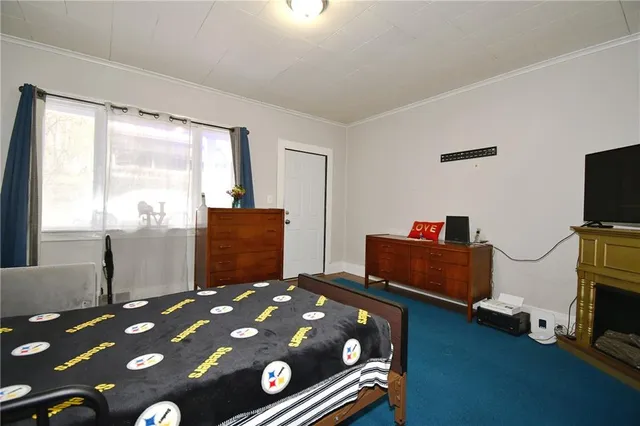 a bedroom with a bed and a flat tv screen on the dresser