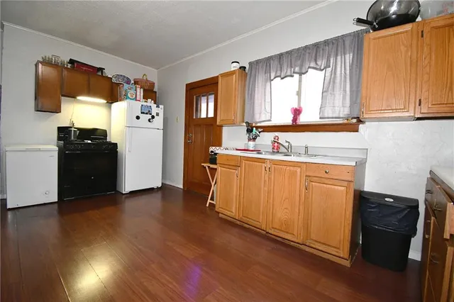 a living room with stainless steel appliances kitchen island granite countertop wooden floor a dining table and chairs