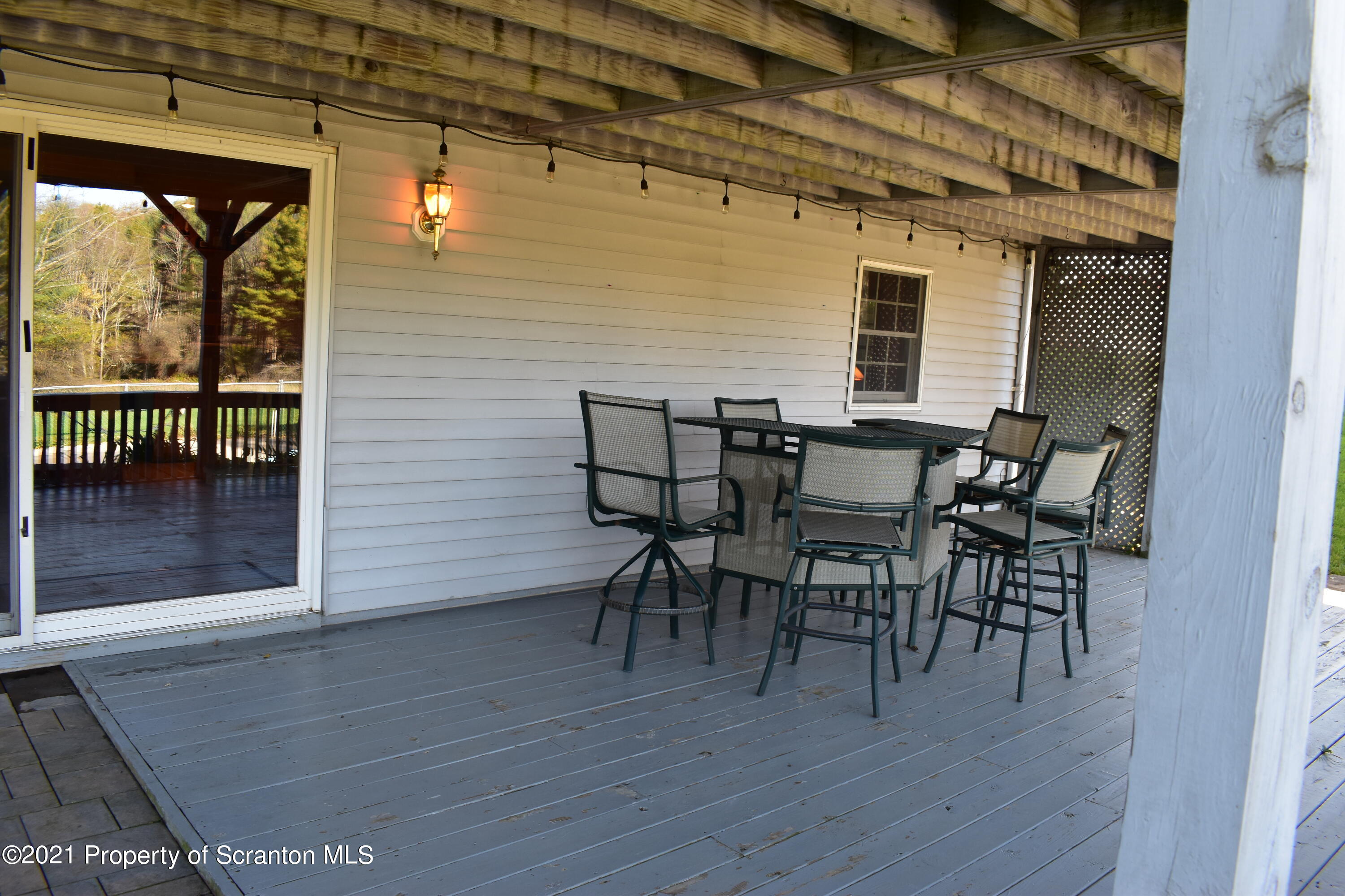 15375 State Rte 3001 Montrose, PA 18801 - Photo 52 of 82 a view of a patio with table and chairs with wooden floor and floor to ceiling window