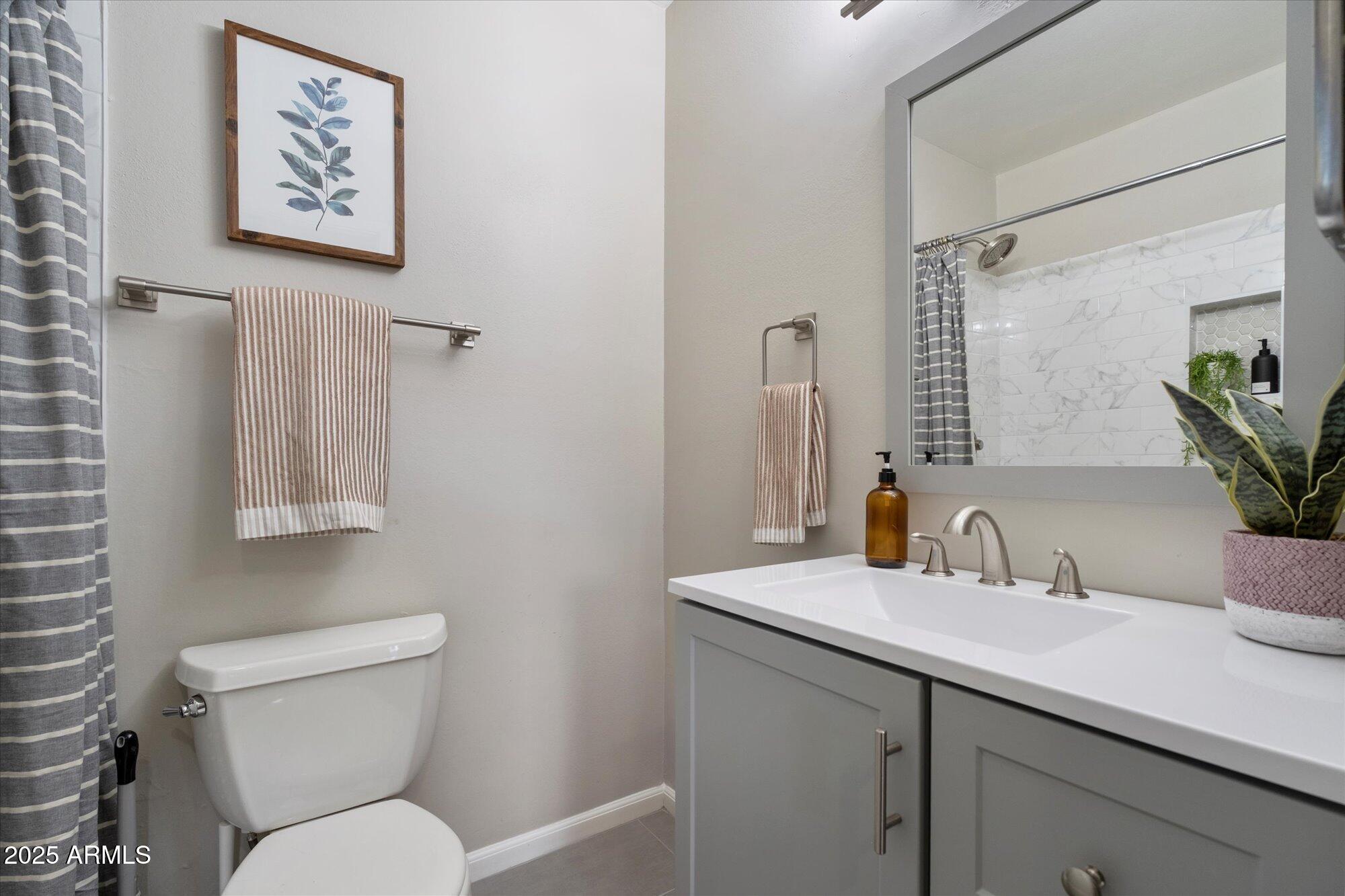 1450 East Bethany Home Road, Unit 8 Phoenix, AZ 85014 - Photo 13 of 29 a bathroom with a toilet sink and mirror