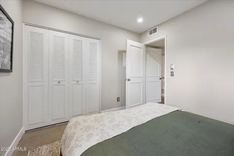 a bedroom with a bed and a painting on the wall