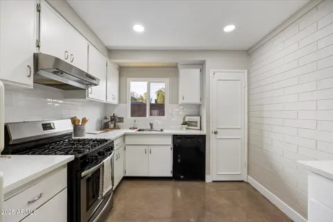 a kitchen with stainless steel appliances a sink stove and cabinets