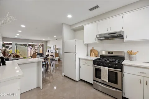 a kitchen with white cabinets and appliances