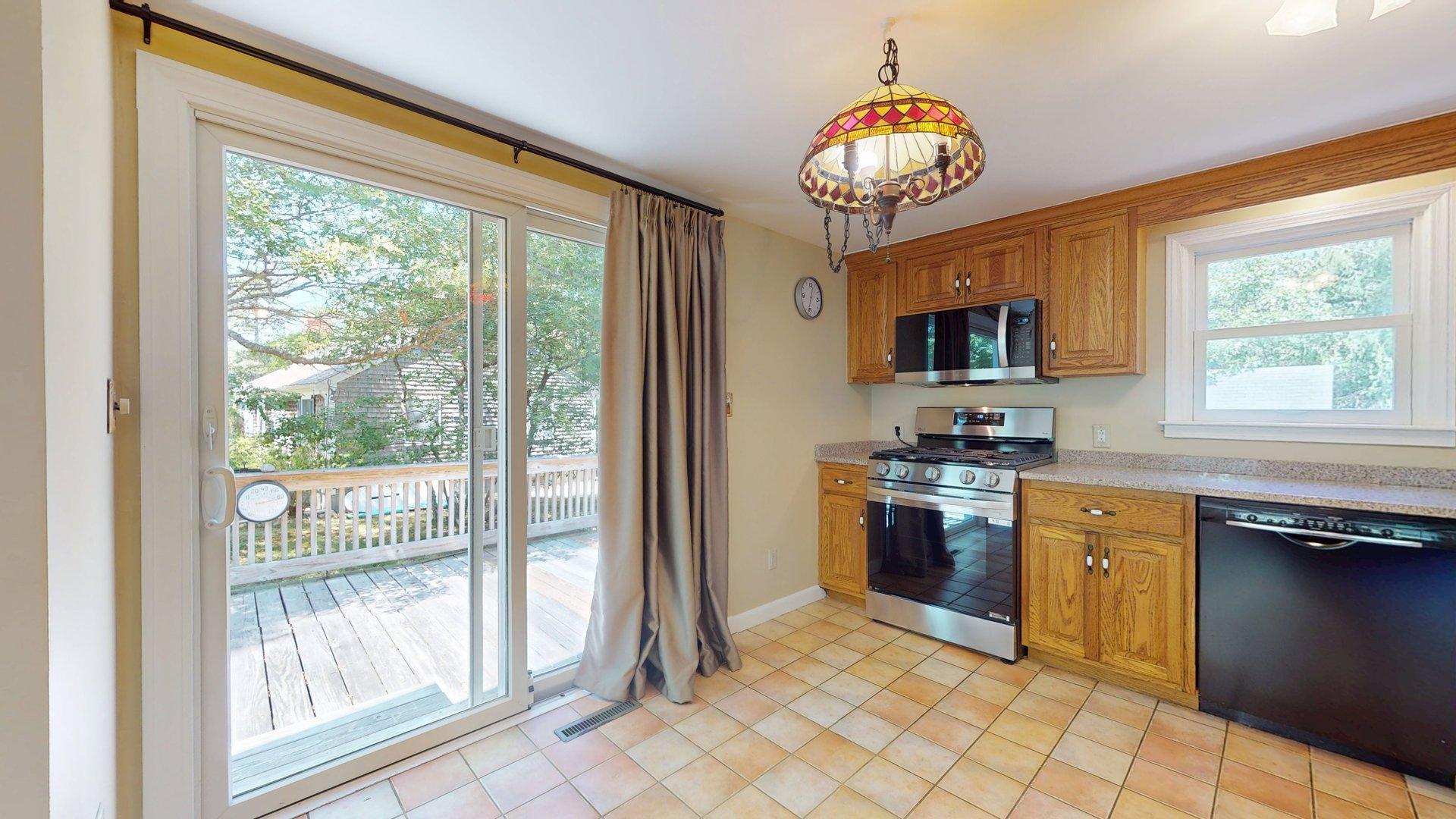 26 Newport Road Brewster, MA 02631 - Photo 16 of 61 a kitchen with stainless steel appliances granite countertop a stove top oven microwave and a dining table