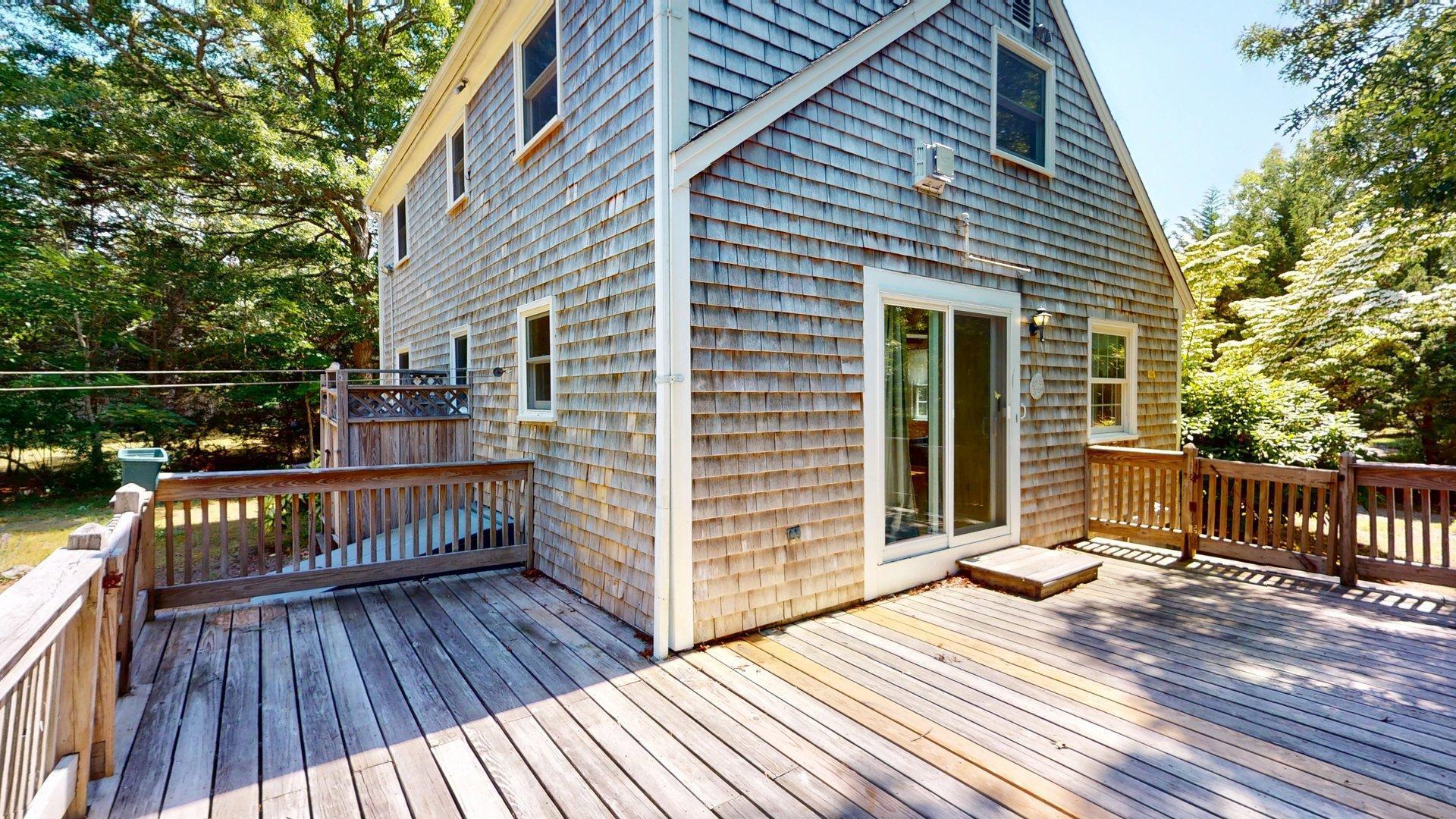 26 Newport Road Brewster, MA 02631 - Photo 40 of 61 a view of a wooden deck with a yard