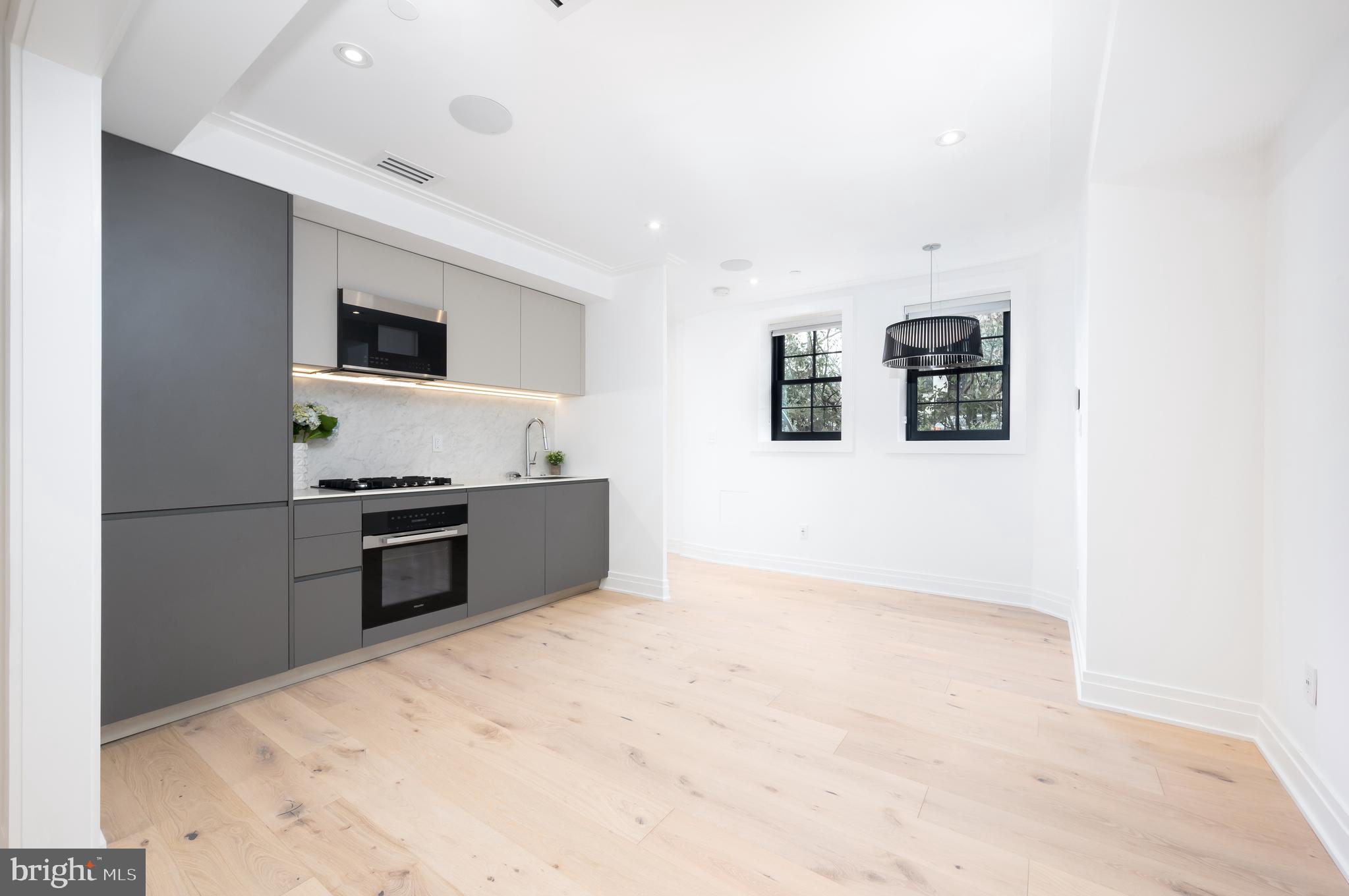 1204 Q Street Northwest, Unit 1 Washington, DC 20009 - Photo 8 of 12 a kitchen with stainless steel appliances a refrigerator and a stove top oven