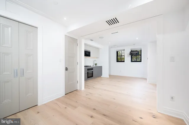 a view of a big room with wooden cabinet and windows