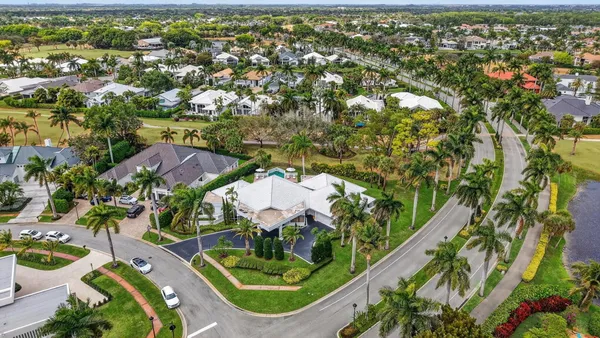 an aerial view of residential houses with outdoor space and trees