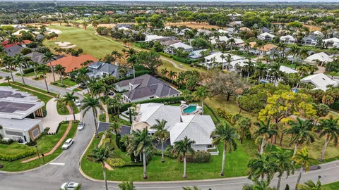 an aerial view of residential houses with outdoor space and trees