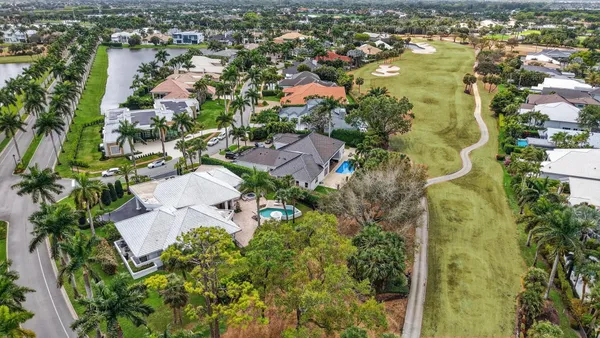 an aerial view of residential houses with outdoor space and trees