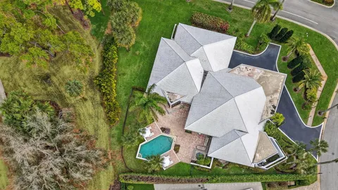 an aerial view of a house with outdoor space and a fountain