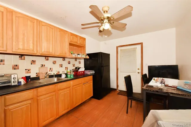 a kitchen with stainless steel appliances sink stove refrigerator dining table and chairs