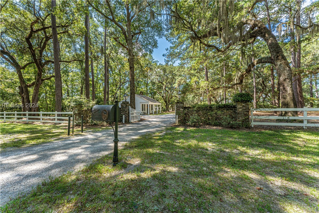 92 Dean Hall Road Seabrook, SC 29940 - Photo 35 of 99 Interior gate; classic masonry & wooden / rail fence "arrival" entrance; mail and service providers separate route just right of this entrance