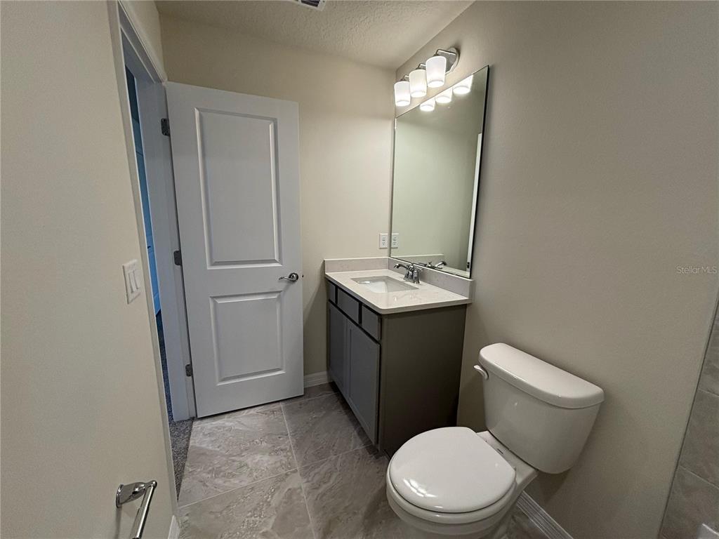 16274 Bright Leaf Road Winter Garden, FL 34787 - Photo 29 of 38 a white toilet sitting next to a bathroom sink and vanity