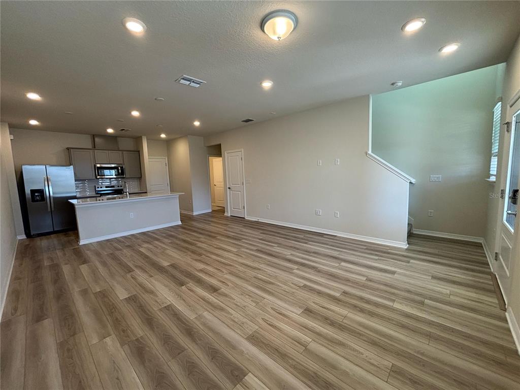 16274 Bright Leaf Road Winter Garden, FL 34787 - Photo 3 of 38 a view of kitchen and empty room with wooden floor