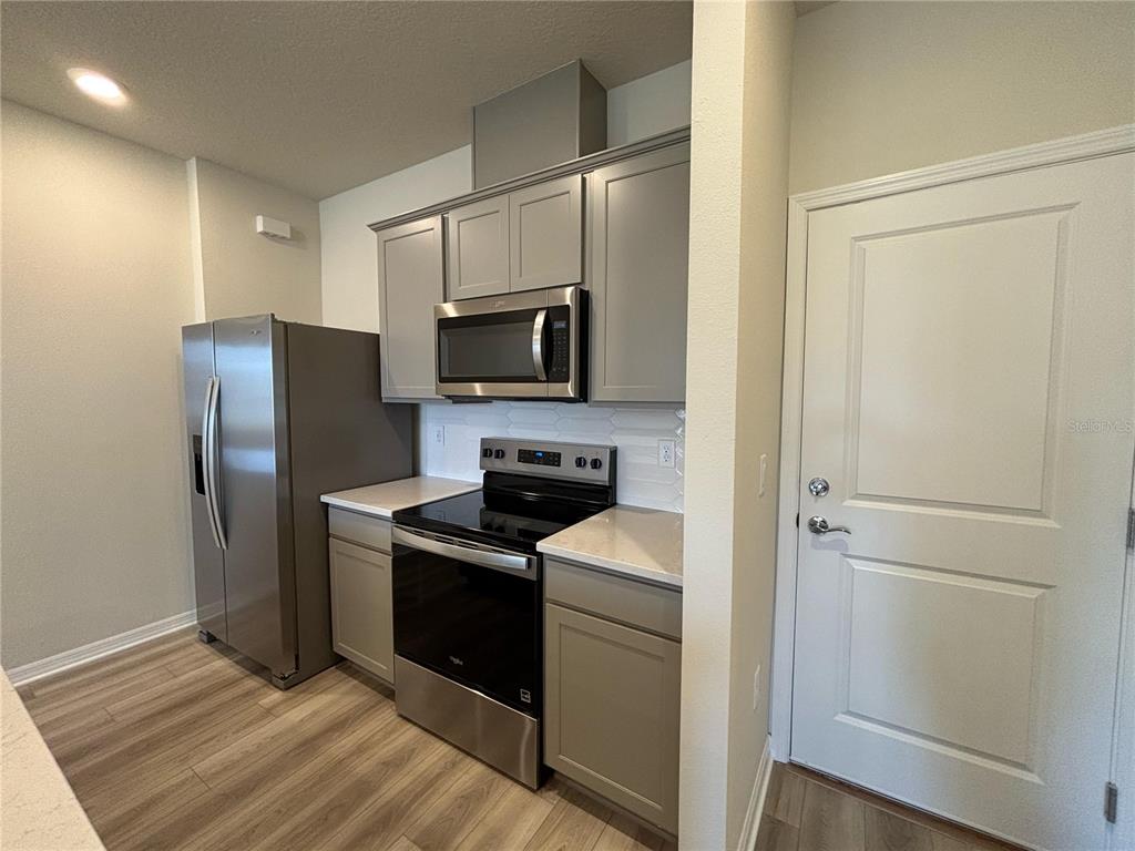 16274 Bright Leaf Road Winter Garden, FL 34787 - Photo 7 of 38 a kitchen with a refrigerator stove and microwave