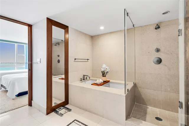 a bathroom with a tub and a glass door shower