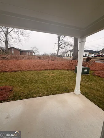 a view of a white house with a yard in front of it