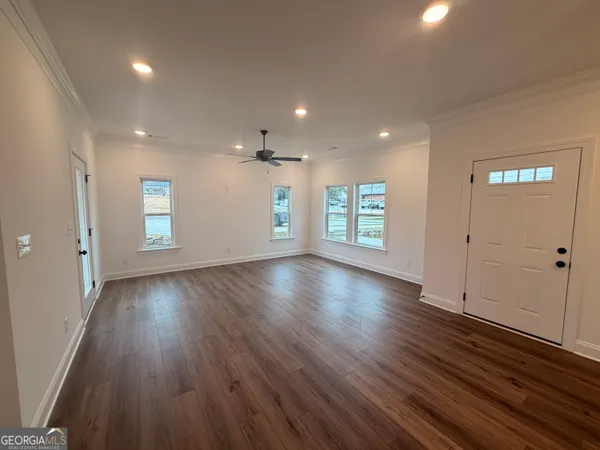 an empty room with hard wood floors and windows