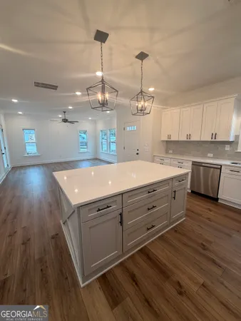 a view of a kitchen counter space a sink wooden floor cabinetry and kitchen view