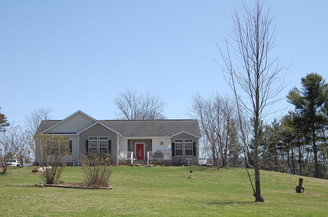 278 Dusty Rock Road Northwest Riner, VA 24149 - Photo 2 of 21 a front view of a house with a garden and trees