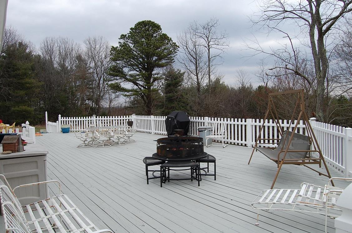 278 Dusty Rock Road Northwest Riner, VA 24149 - Photo 14 of 21 a view of a patio with dining table and chairs with wooden floor and fence