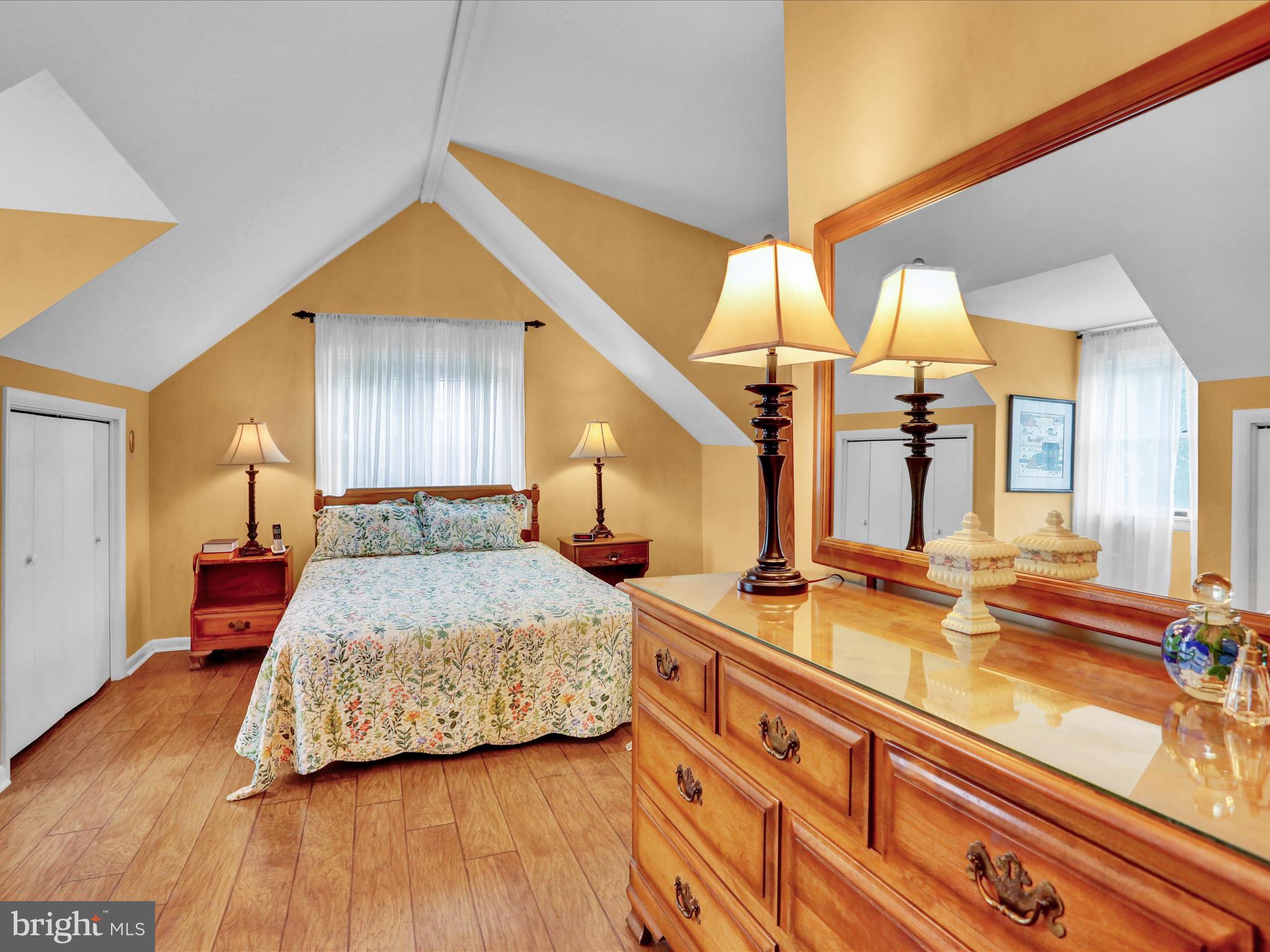 115 Mayer Street Reading, PA 19606 - Photo 33 of 48 a bedroom with a bed a dresser and potted plants with wooden floor